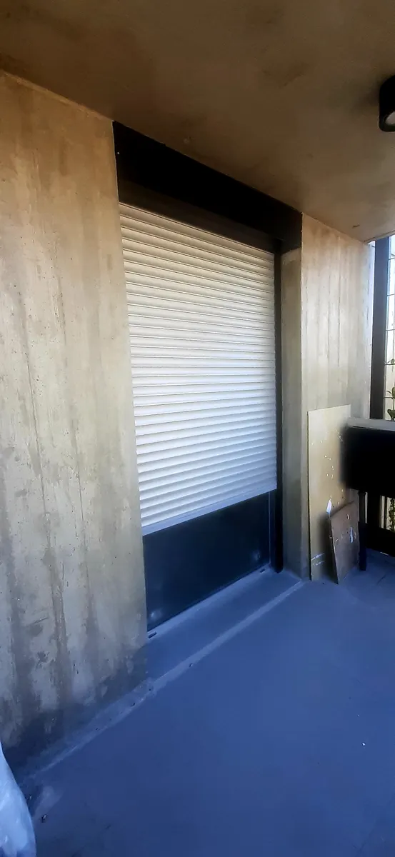 Persiana de aluminio blanca instalada en balcón en obra